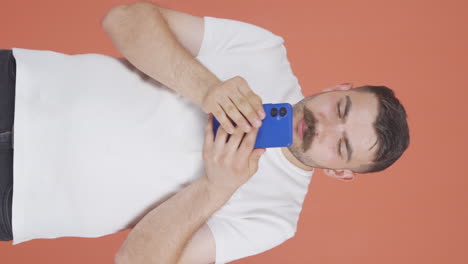 Vertical-video-of-The-man-who-happily-puts-the-phone-to-his-heart.